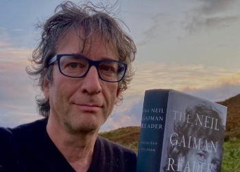 Neil Gaiman segura seu livro publicado nas mãos. Foto de sua conta no Instagram