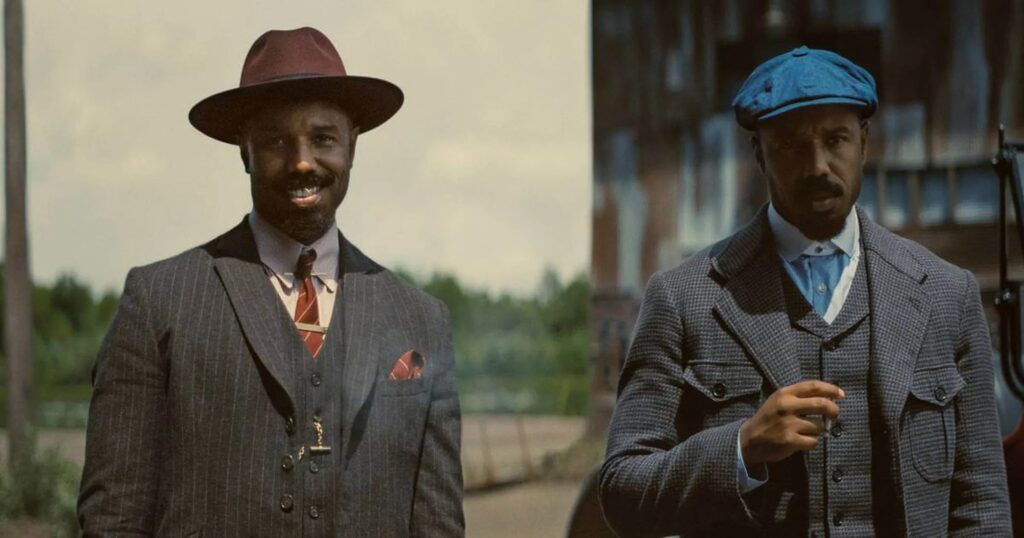 Cena do filme Pecadores (2025) mostrando os irmãos interpretados por Michael B. Jordan com trajes de época dos anos 1930.