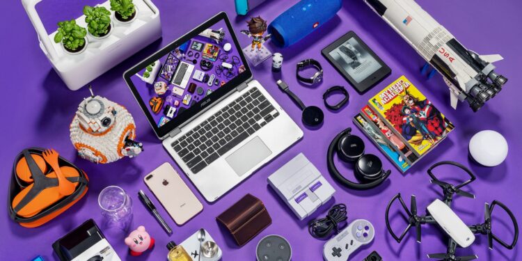 Uma coleção de gadgets e itens de cultura pop arranjados sobre uma superfície roxa, incluindo um laptop, smartphone, drone e console de videogame, ilustrando o tema da dependência tecnológica.