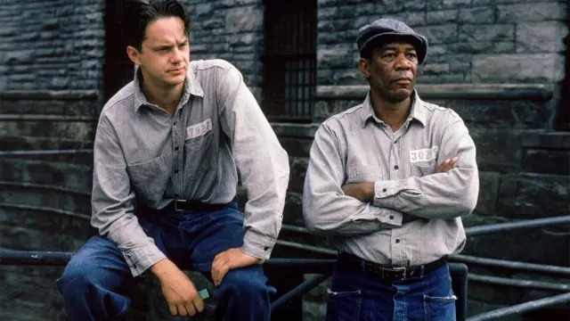 Cena do filme Um Sonho de Liberdade com os personagens Andy Dufresne, interpretado por Tim Robbins, e Red, vivido por Morgan Freeman, no pátio da prisão de Shawshank.