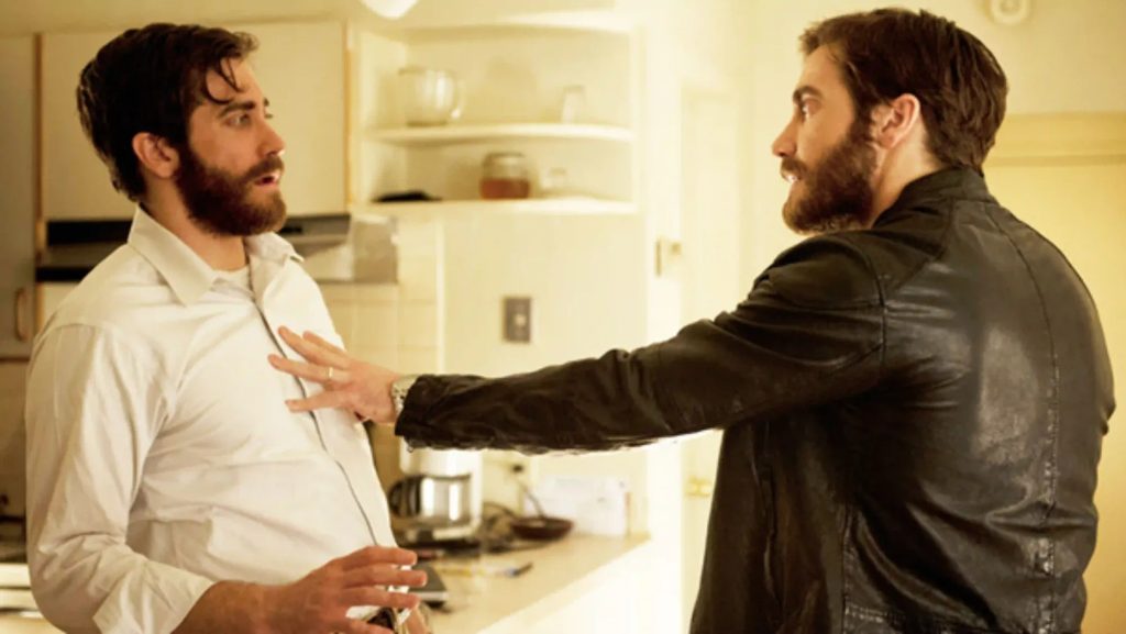 Jake Gyllenhaal como os personagens Adam e Anthony se confrontando em uma cozinha na cena do filme O Homem Duplicado.