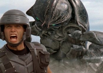 Johnny Rico correndo desesperado com um inseto alienígena Arachnid em perseguição, cena do filme Tropas Estelares.