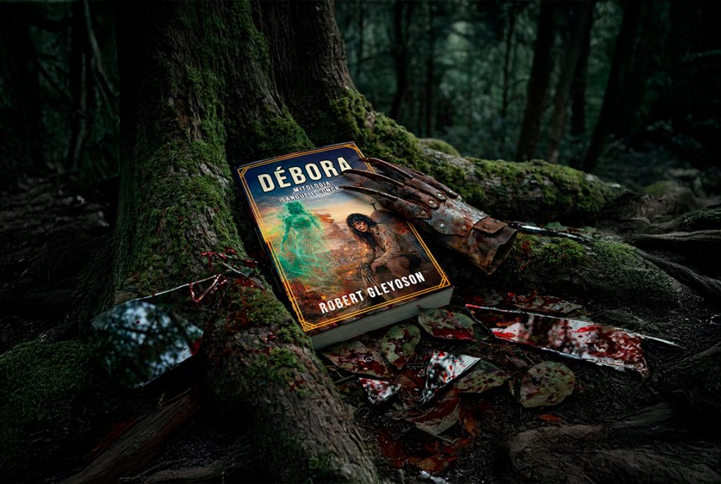 Capa do livro de horror "Débora: Mitologia, Sangue e Concreto" de Robert Gleydson, apoiado na raiz de uma árvore coberta de musgo em uma floresta escura. Ao lado, uma luva com garras metálicas estilo Freddy Krueger e cacos de espelho quebrados e ensanguentados. A cena é sombria e atmosférica.