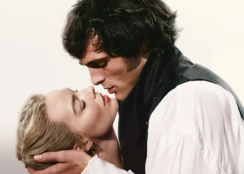 Cena de perfil estilizada de Jacob Elordi como Heathcliff e Margot Robbie como Catherine em trajes de época, inclinando-se para um beijo íntimo no filme Wuthering Heights (2026).
