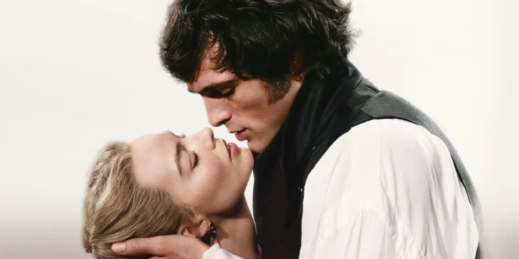 Cena de perfil estilizada de Jacob Elordi como Heathcliff e Margot Robbie como Catherine em trajes de época, inclinando-se para um beijo íntimo no filme Wuthering Heights (2026).